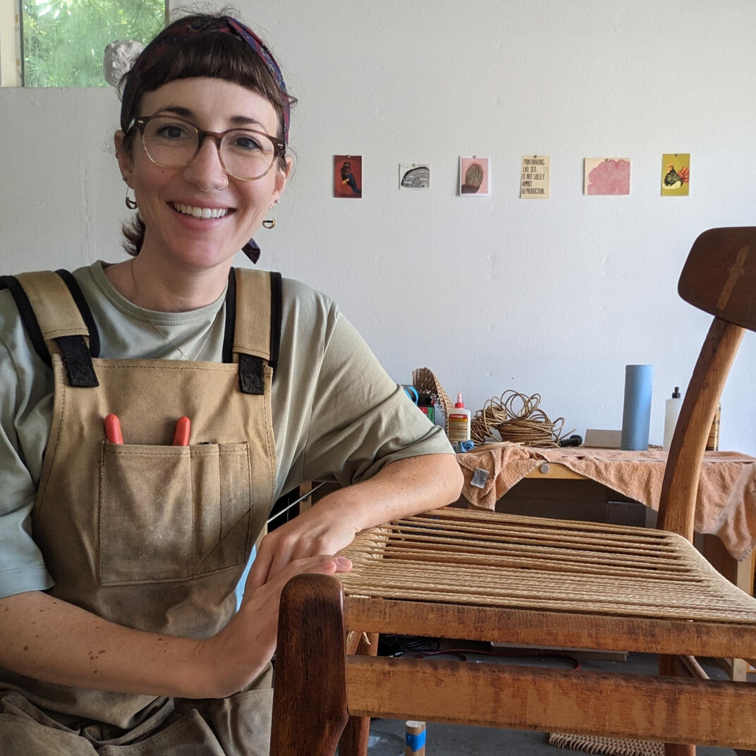photo of the artist weaving a mid-century Danish chair